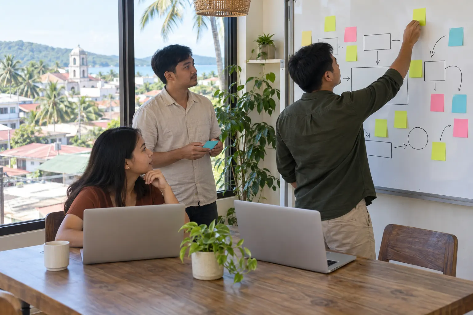 Illustrative: a small team planning an app at a whiteboard of sticky notes and hand-drawn boxes